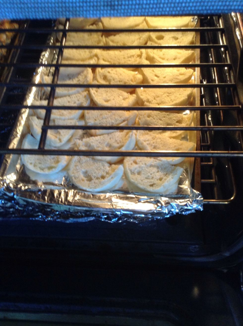 Meanwhile, cut the English muffins in half, put them on a foil-lined baking pan and put them in a 350\u00b0 F oven to toast for a few minutes until they start to turn golden around the edges.