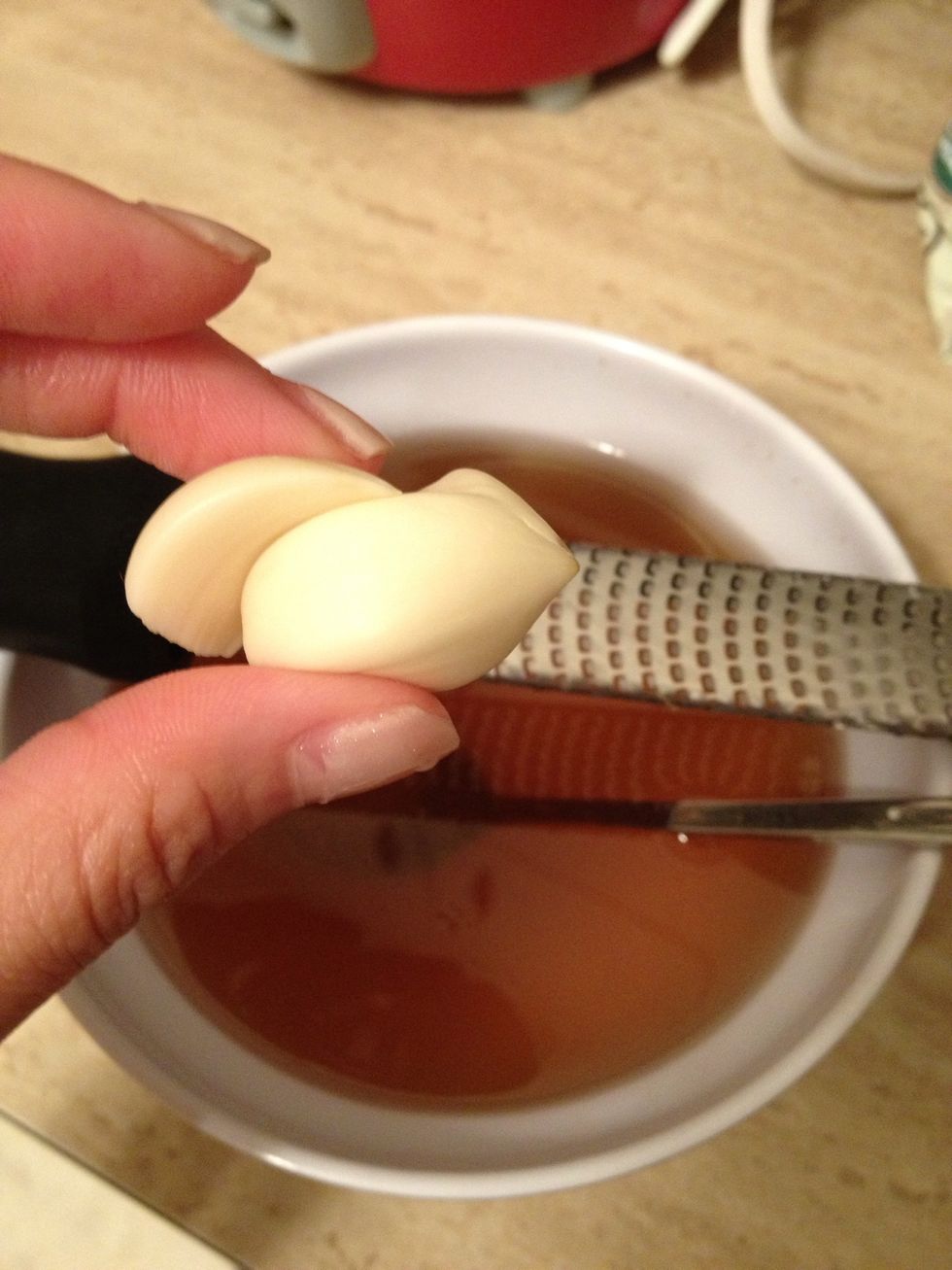Meanwhile, grate 1 or 2 cloves garlic over bowl into mixture.