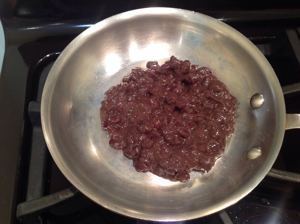 Meanwhile, in a small saut\u00e9 pan over low heat cook your black beans until warm. I'm using pre-seasoned beans containing onions and poblano chilies.