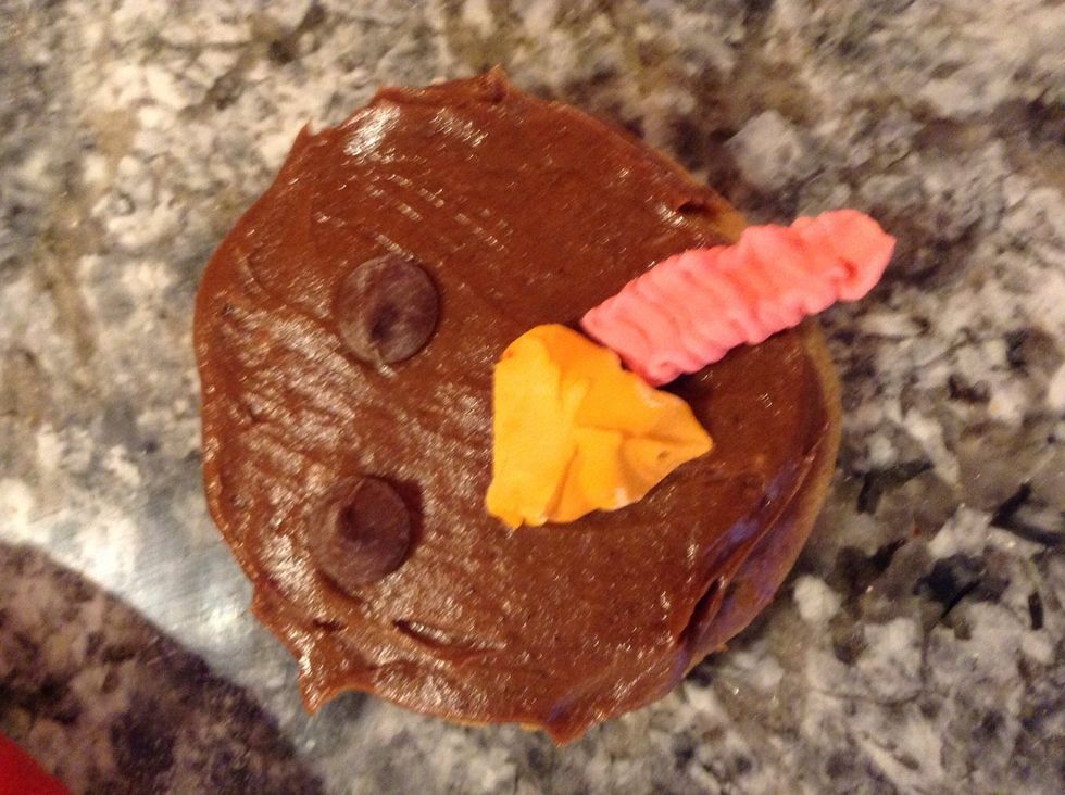Meanwhile, make the face. I tok a cookie and put on chocolate chip eyes and a royal icing beak.