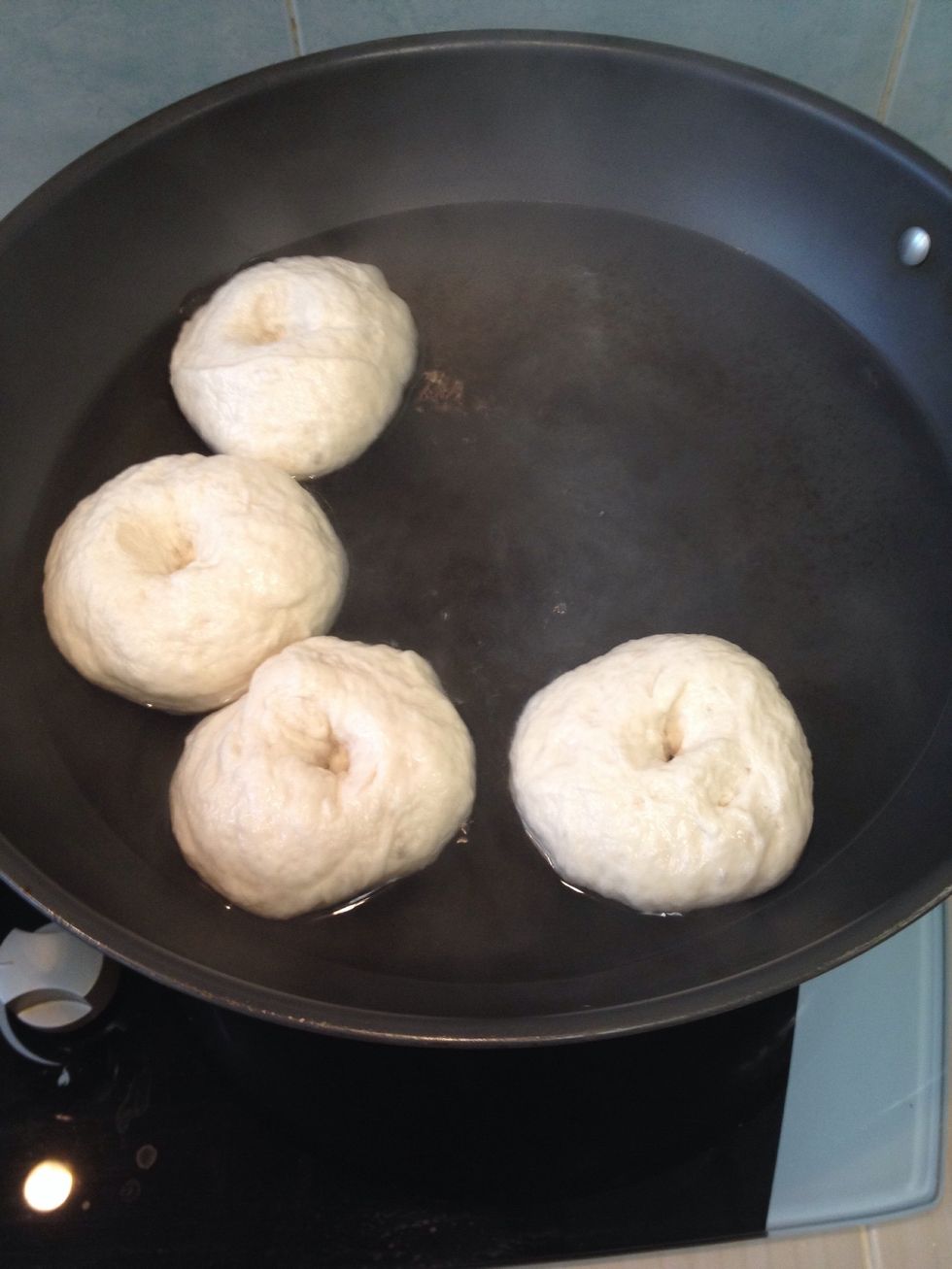 Meanwhile, preheat your oven to 220c and bring a pot of water to a boil. Reduce the heat & lower the bagels into the water. Let them sit there for 1 minute, then flip them over for 1 more minute.