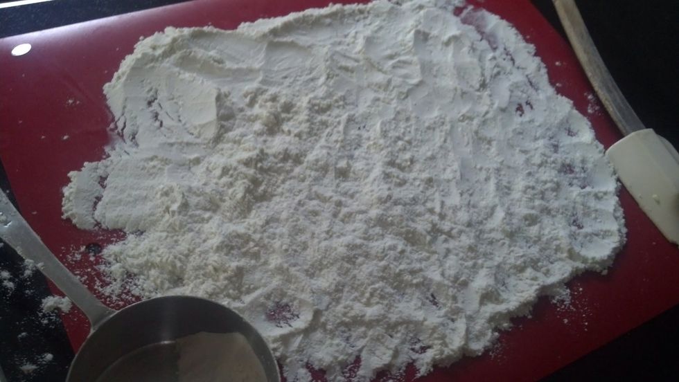 Measure 1 cup of flour on a board. Spread it out to almost cover the board.  Set aside, we will use this later once the dough is made.