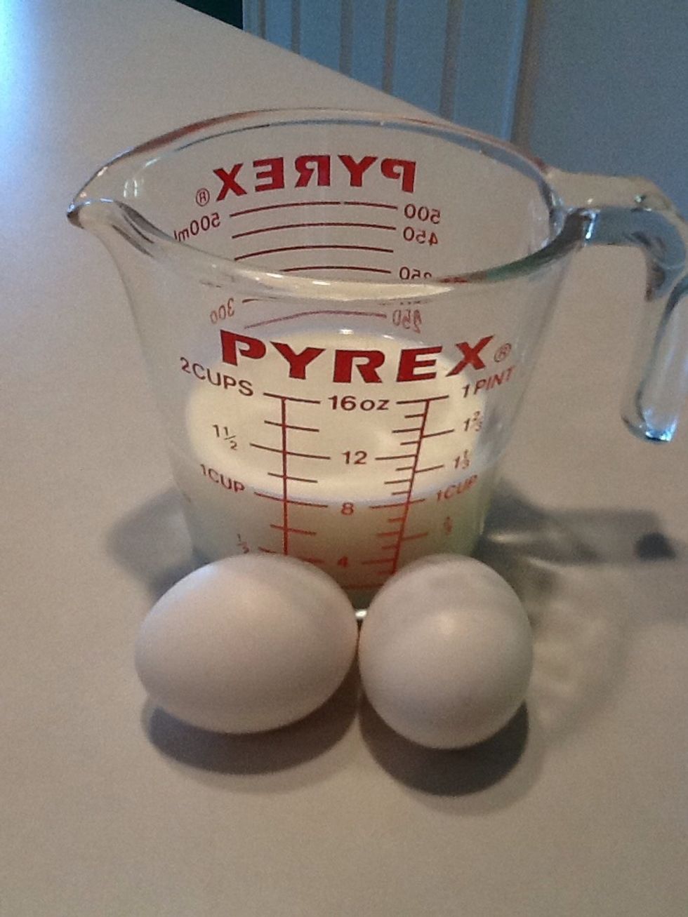 Measure 1 cup of milk.  Crack two eggs and add them to the milk.