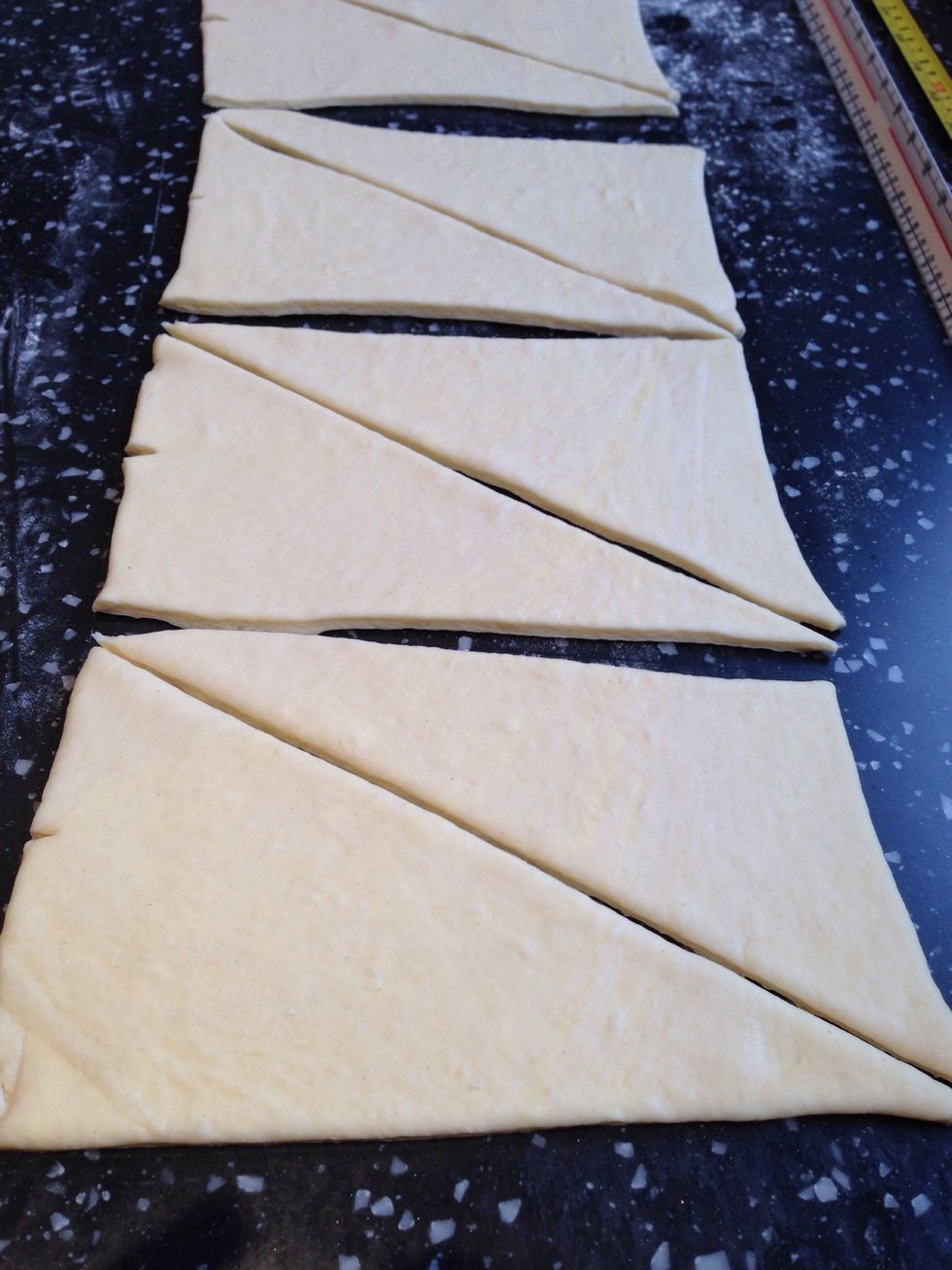 Measure 12.5cm slits along the length of the dough and cut at these points to make rectangles. Then cut diagonally to form triangles.