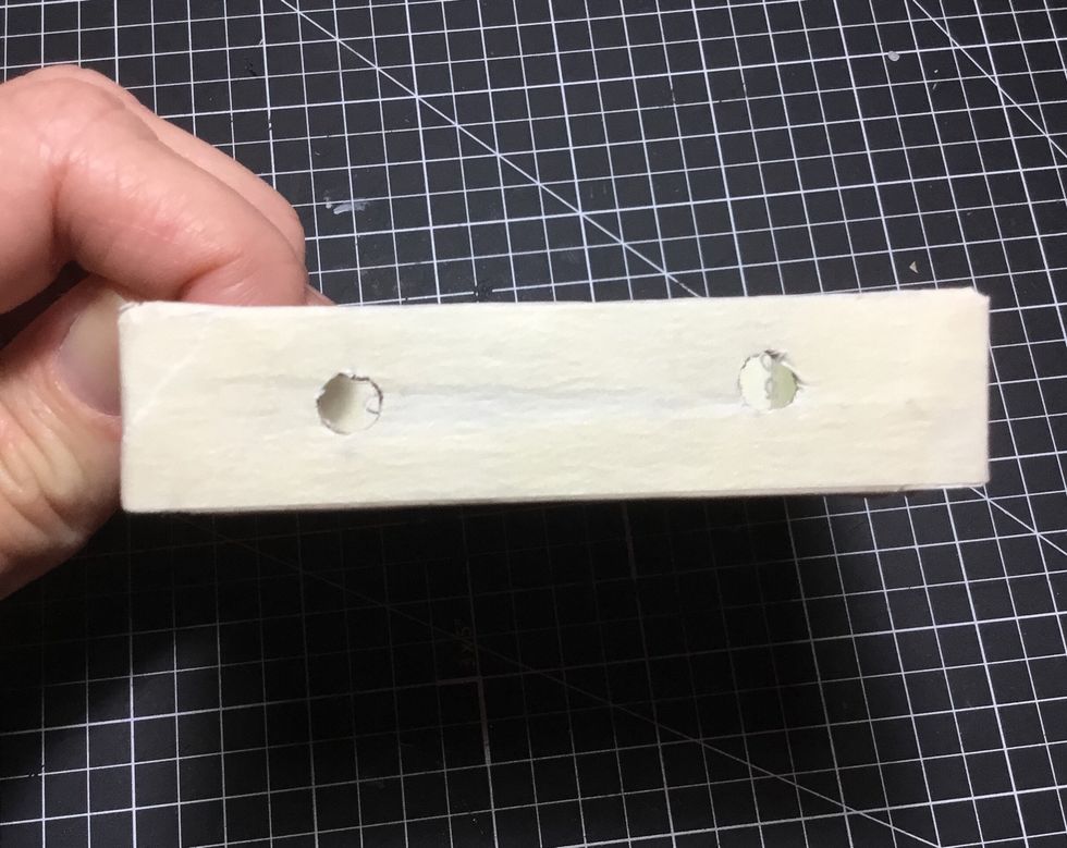 Measure 2cm in from each side of the base on one side only and punch holes as shown. These will allow holes for the handle.
