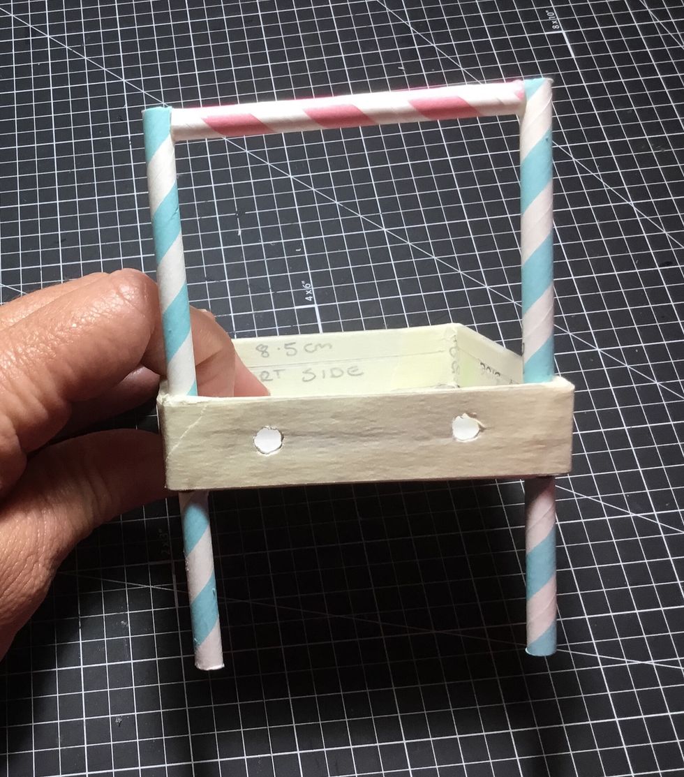 Measure 4cm from the bottom of the front cart legs and mark. Push up through holes in the front of cart base but stop at line mark and glue in as shown. Attach with glue one of the roof frame pieces.