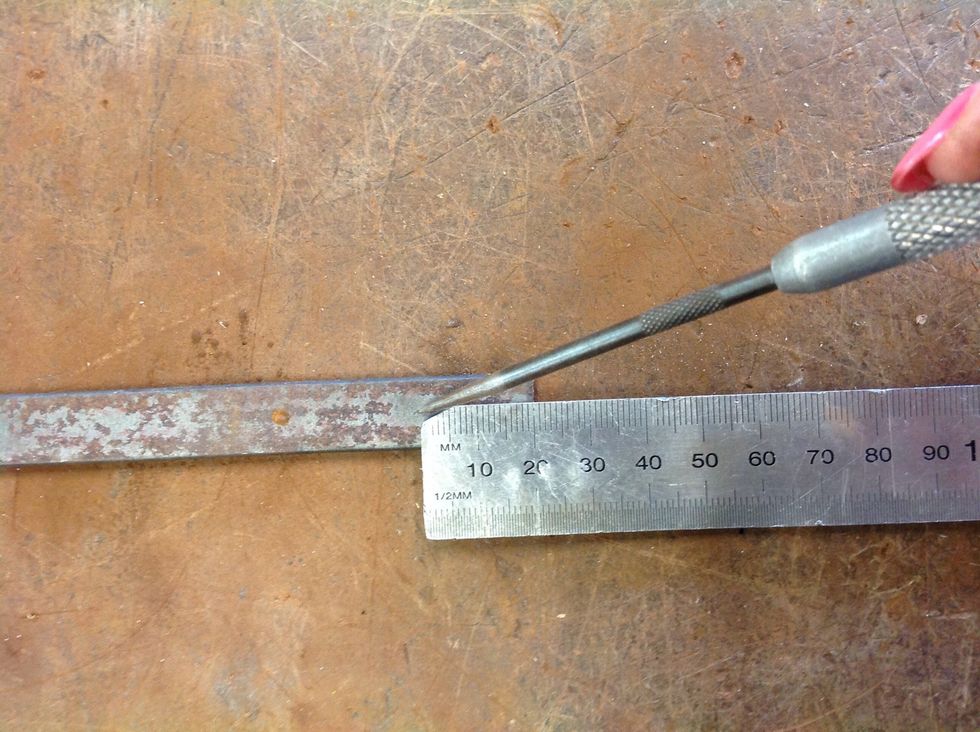 Measure 8cm off the end of the flat bar with the scribe and cut it with a hacksaw...