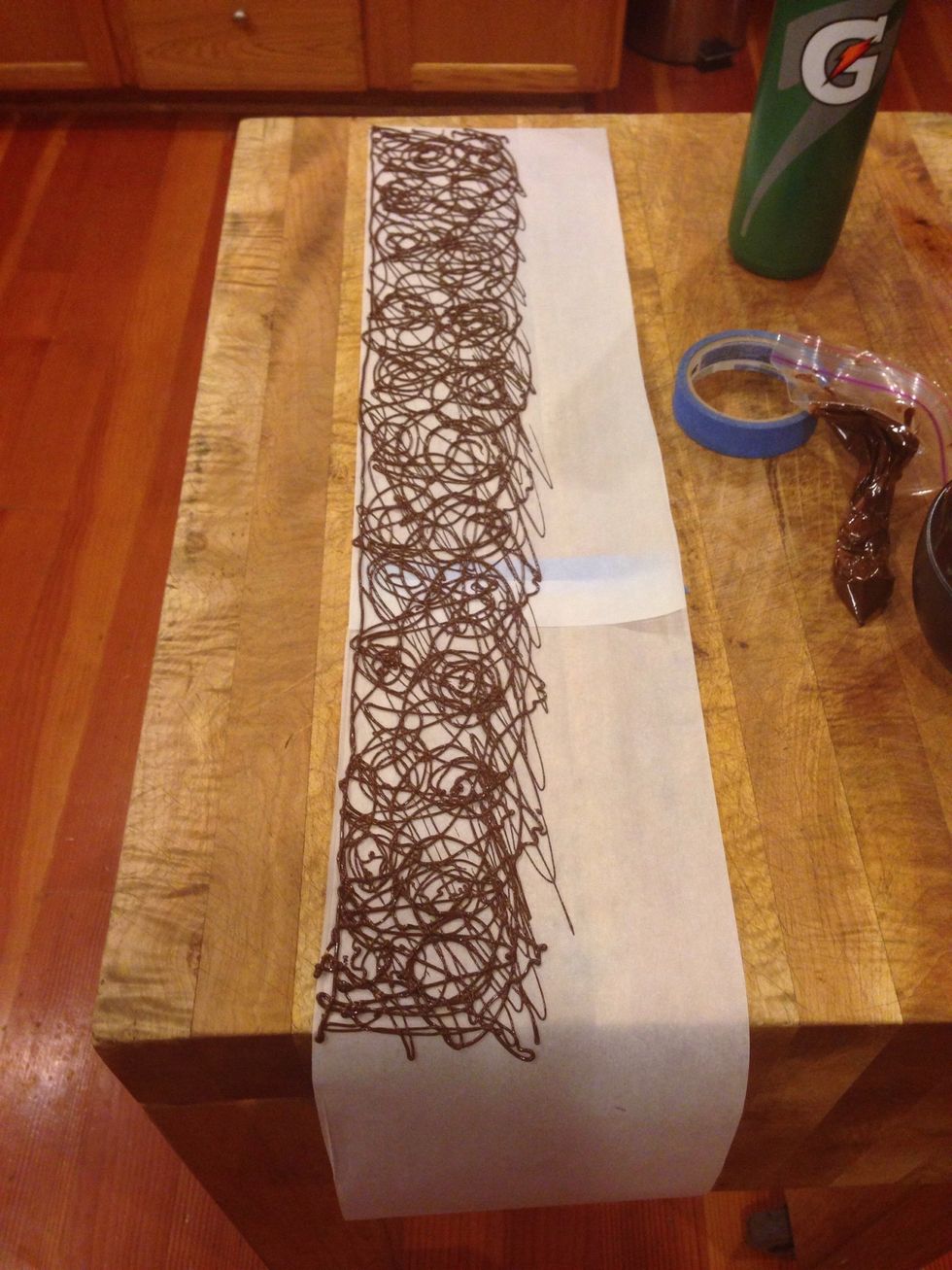 Measure a piece of parchment paper that goes all the way around the cake. Make any design you'd like on the paper, I made swirls, and circles. You could even do letters and words!