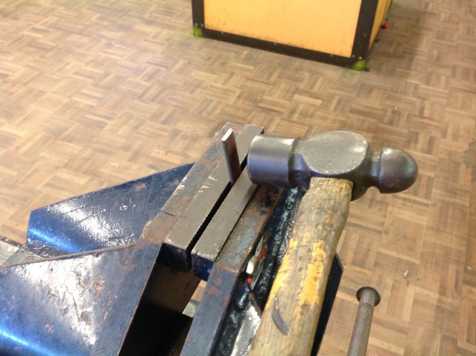 Measure about 1.5cm from the edge of each side of the 8cm piece and draw a line with the scribe. Then line it up with the top of the vice and use your ballpin hammer to hammer the metal to bend the it