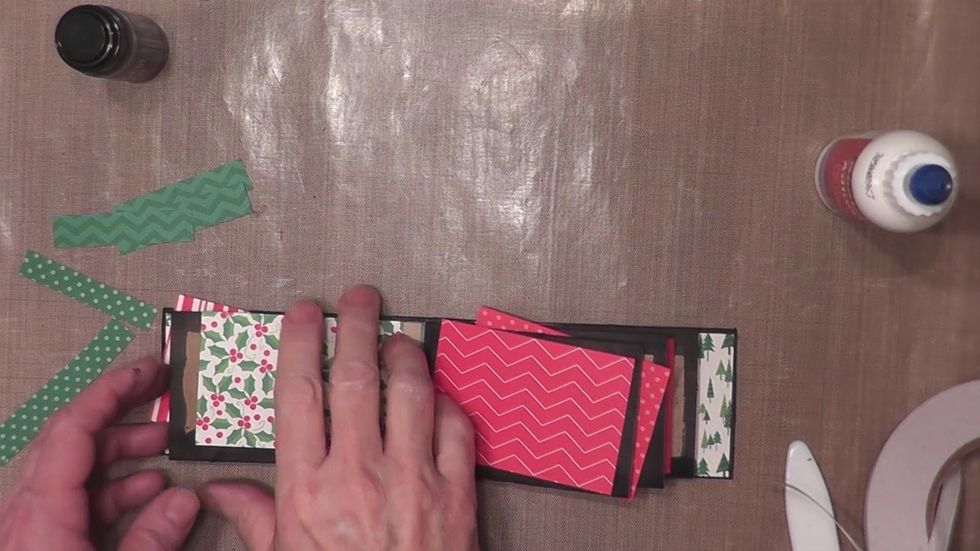 Measure and cut decorative patterned paper to cover each page front and back. Attach the papers with glue and burnish with your hands.