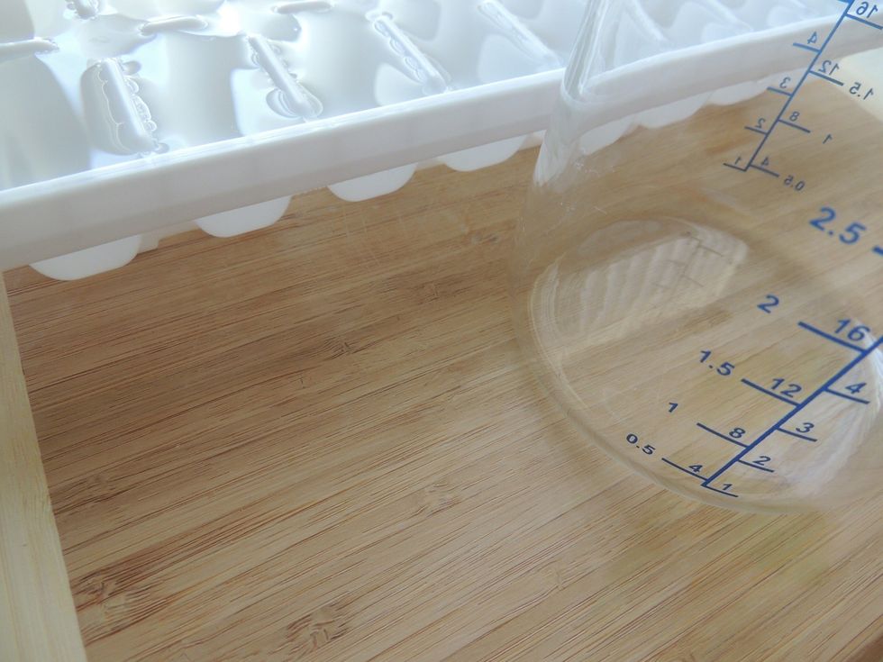 Measure how much your ice tray will hold. Fill it with water and pour into measuring cup. Note the amount and empty the measuring cup.