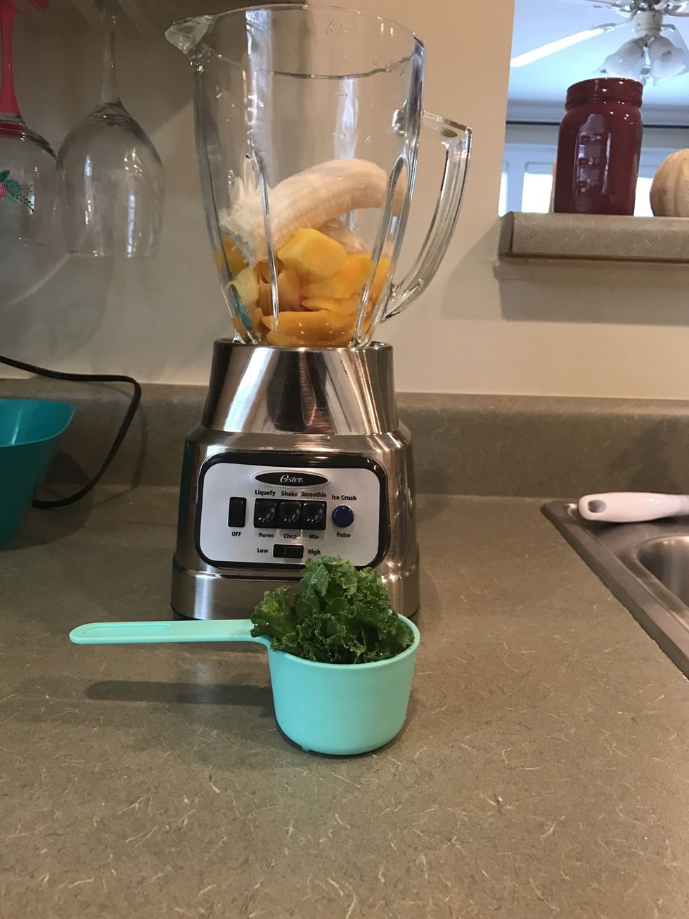 Measure out 1/2 cup of kale and add it to the blender. Make sure the fresh kale has been washed!