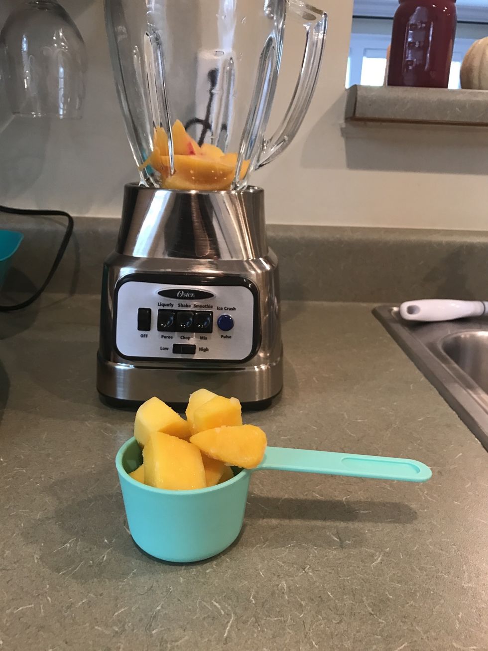Measure out 1/2 cup of mango chunks and add them to the blender