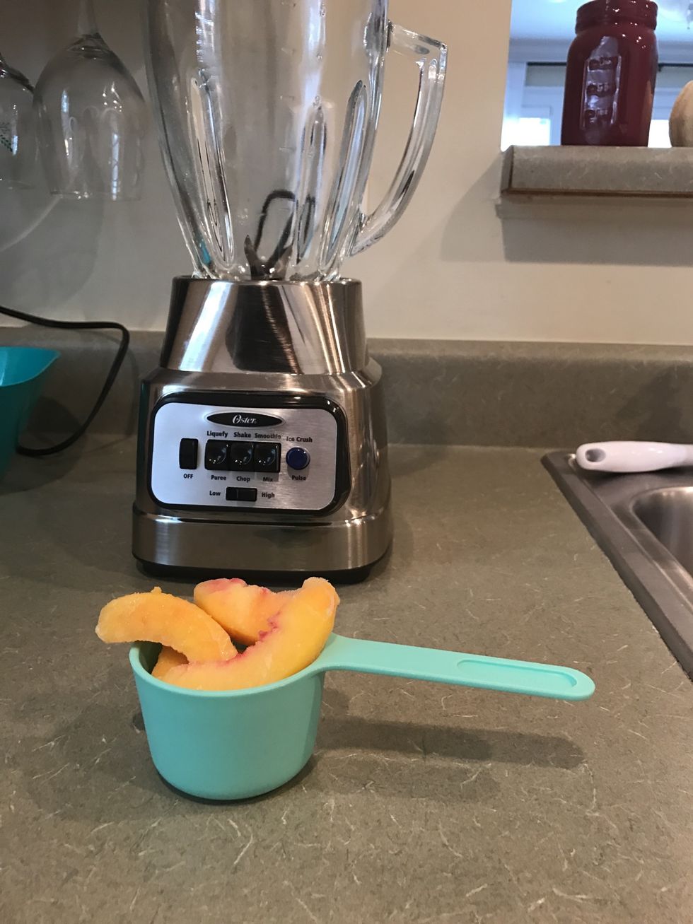Measure out 1/2 cup of peach slices and add them to the blender