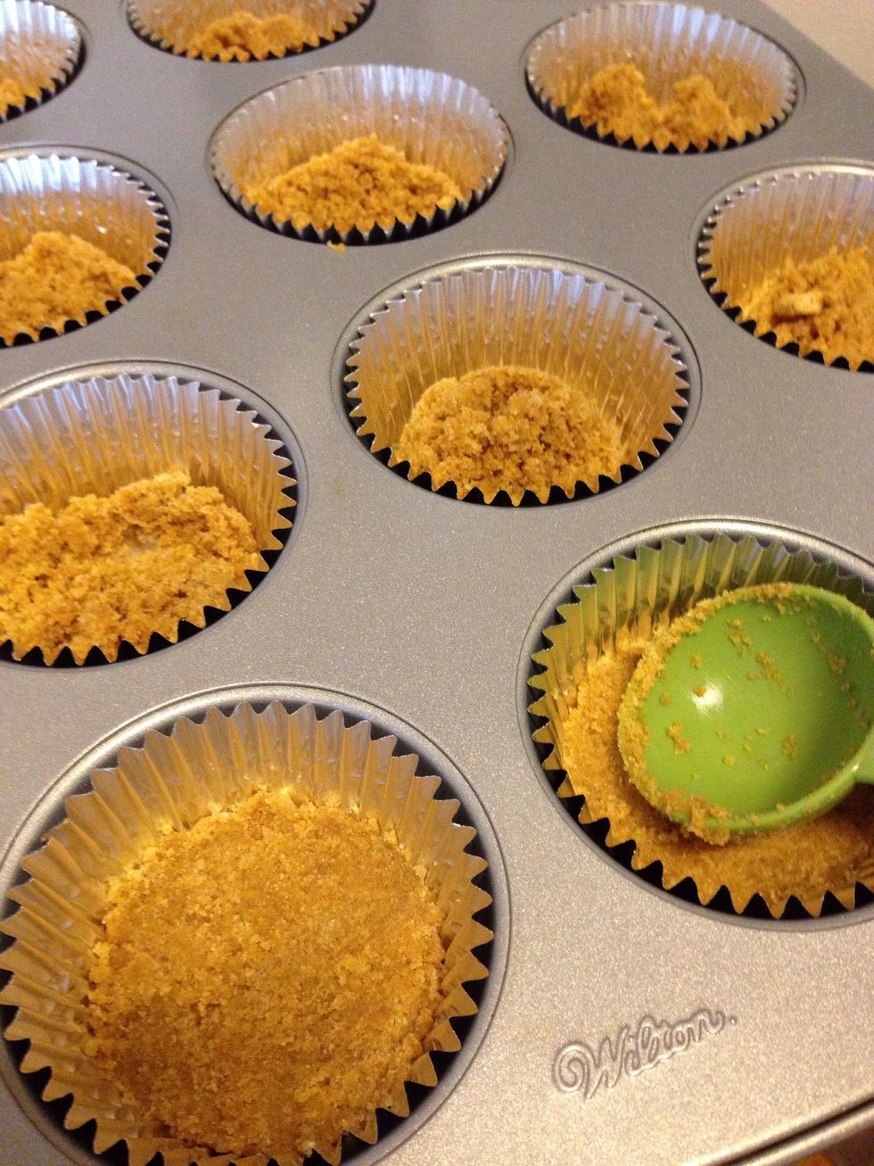 Measure out 1 tablespoon of crumbs and place in each liner, pressing down firmly to make a crust. Place in preheated 350* oven for 5 minutes, remove, and set aside