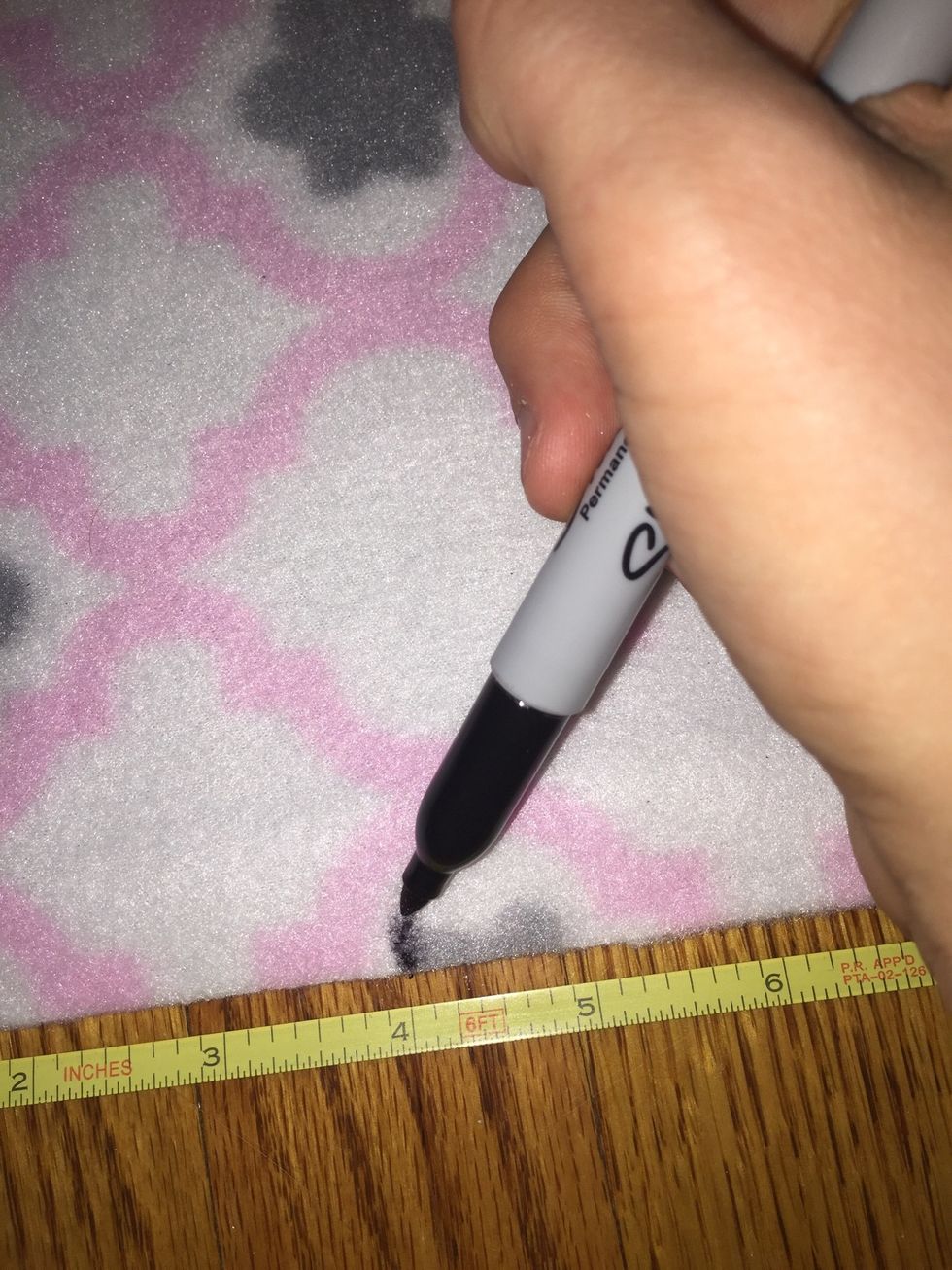 Measure out a 4 inch square on each corner of the blanket and make small marks with a Sharpie.