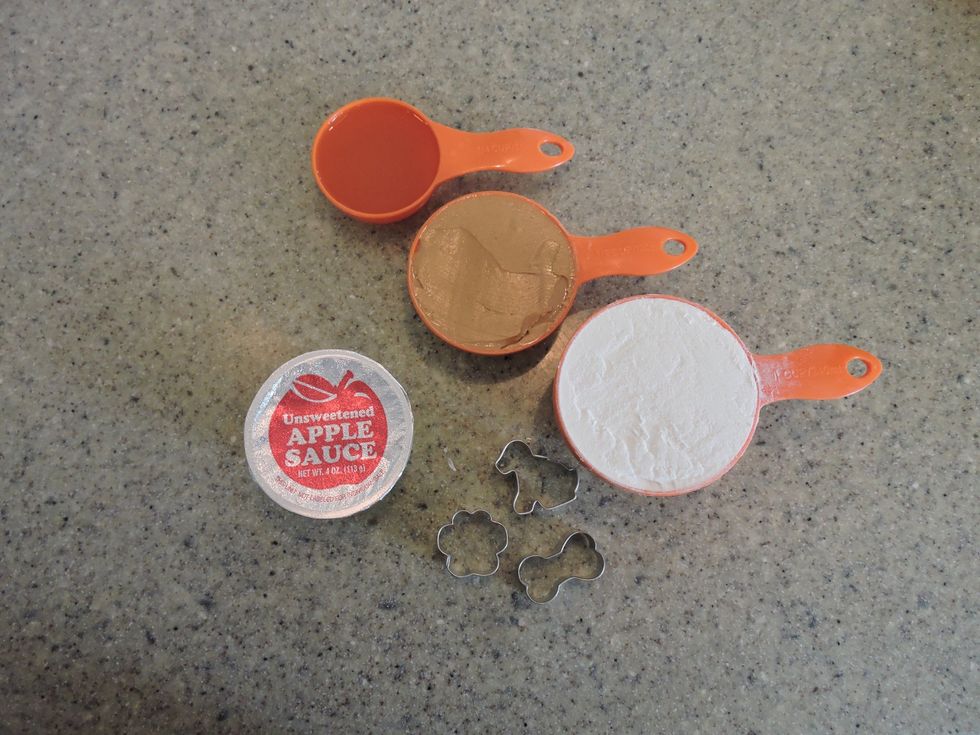 Measure out the ingredients (1 cup flour, 1/2 cup peanut butter, 1/4 cup apple sauce, 1/4 cup chicken broth).