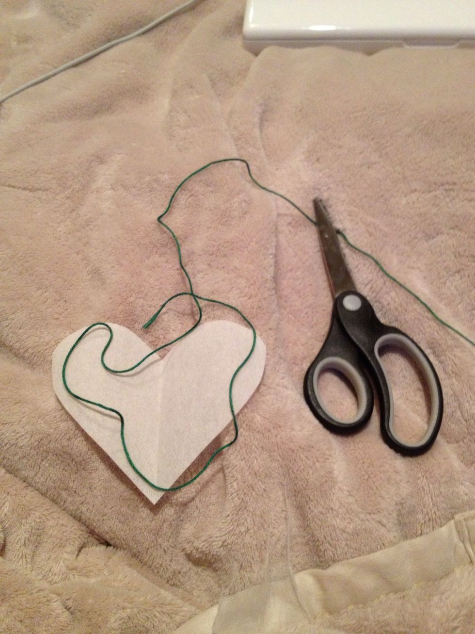 Measure your thread by loosely placing it over the edges of the heart. I'm using green for green tea (easy, eh?). Leave enough slack for the tail. I'll cut just to the right of the scissors.