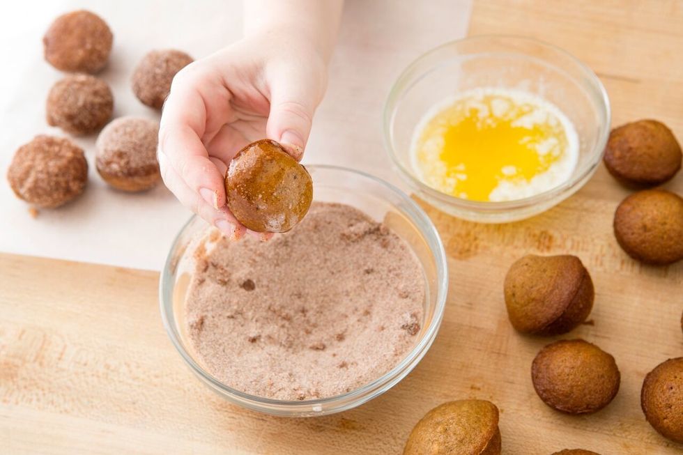 Melt 3 tablespoons of butter in another small bowl. Dip one side of your donut hole in the melted butter.