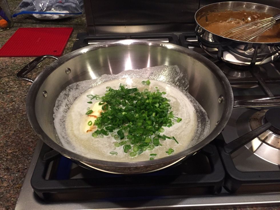 Melt butter and saut\u00e9 green onions briefly