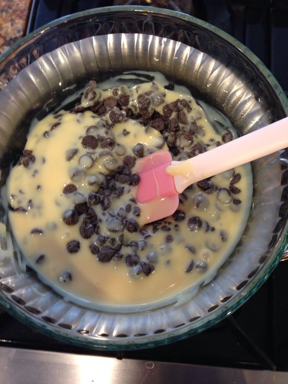 Melt chocolate, and sweetened condensed milk in a double broiler, on medium heat, until chips are almost melted.