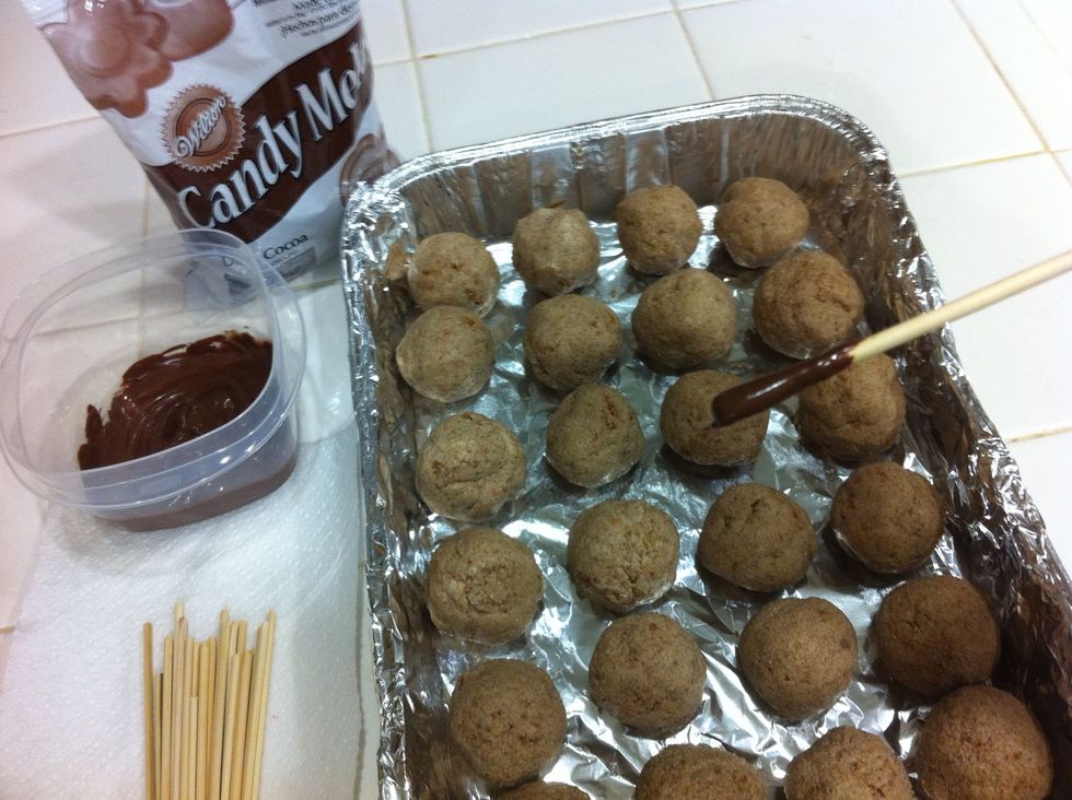 Melt chocolate in the microwave on DEFROST or 50% power setting for 1min... then 30sec intervals till it's liquified. Dip your stick into the melted chocolate and into the cake balls.