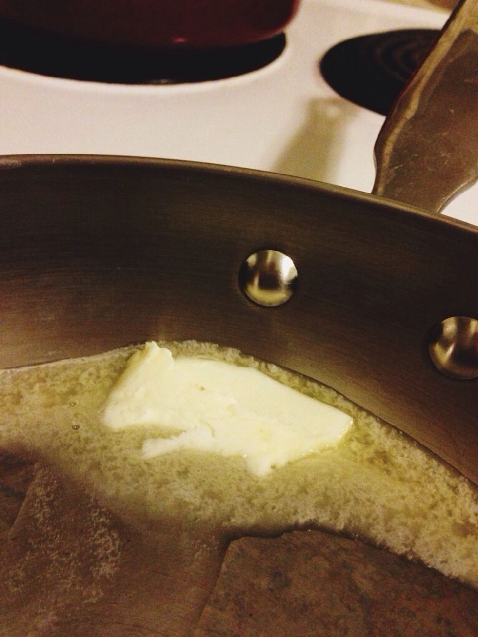 Melt half the butter in a medium skillet over medium heat. The other half will be used to butter the English muffin.