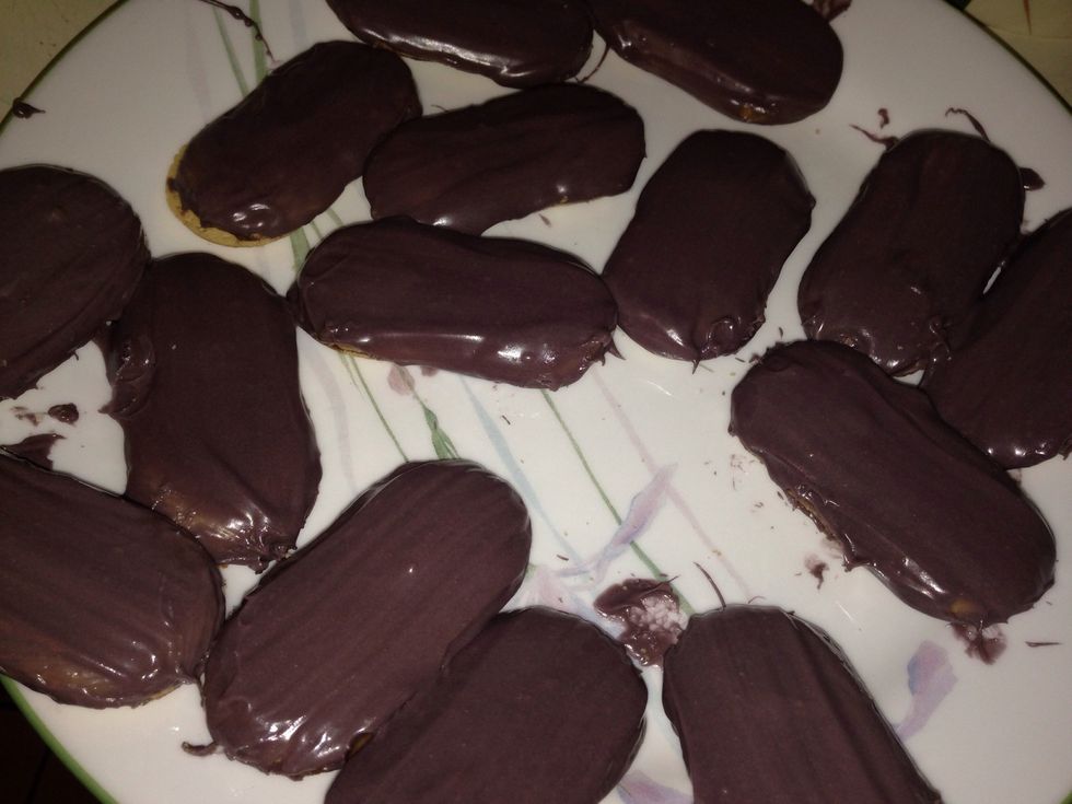 Melt the frosting in the microwave for a few seconds and brush it on. Do one side, put it in the fridge to harden, then take em out and do up the other side and pop them babies back in the fridge