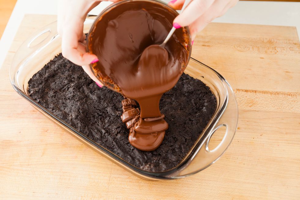 Melt your chocolate chips and pour over top Oreo truffle layer. To melt your chips, place in microwave for 30 seconds and stir. Repeat process until all chips are melted.