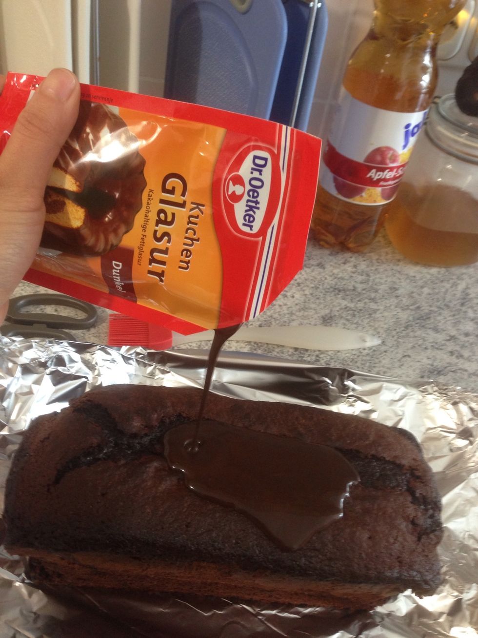 Melt your couverture and cover your cake completely so it will last longer juicy. Take a Brush so it's easier. As long as the couverture is still soft spread your Sprinkles on Top of your cake!