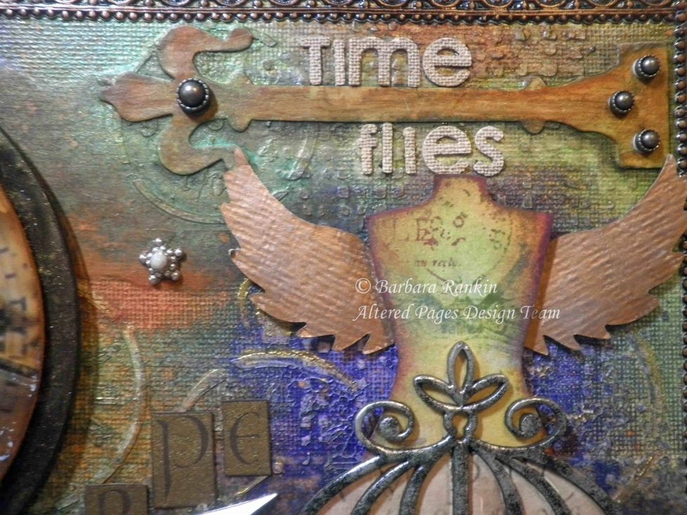 Metal studs were added to the hinges. The wings were glued down beneath the mannequin birdcage, which I also adhered with pop dots.