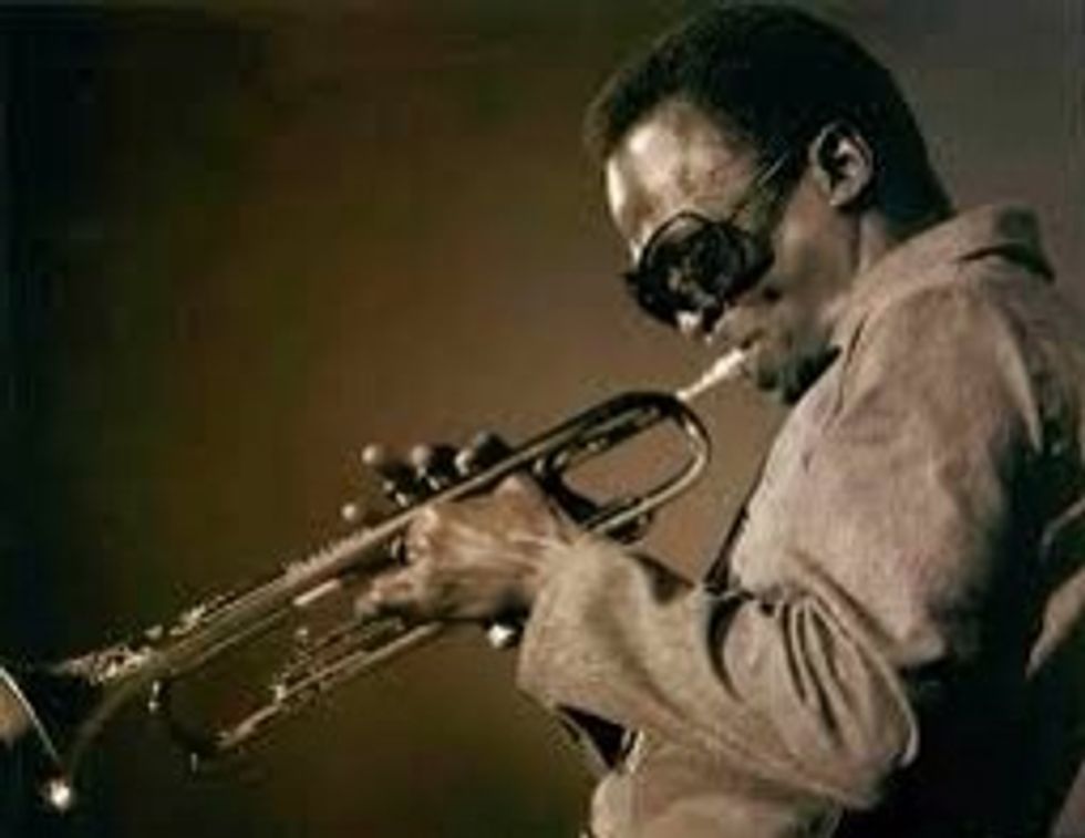 Miles Davis va viure els anys 1926-1991. Va ser un trompetista, compositor i l\u00edder de banda estatunidenc. En aquesta imatge podem veure a Miles Davis tocant la trompeta.