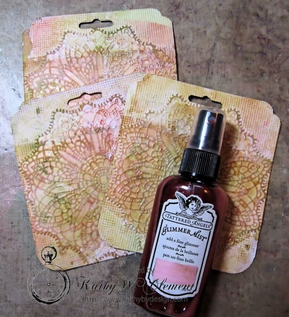 Mist the tag with Tattered Angels Vintage Pink Glimmer Mist. Start with a light coat, then add until you are happy. Heat dry.