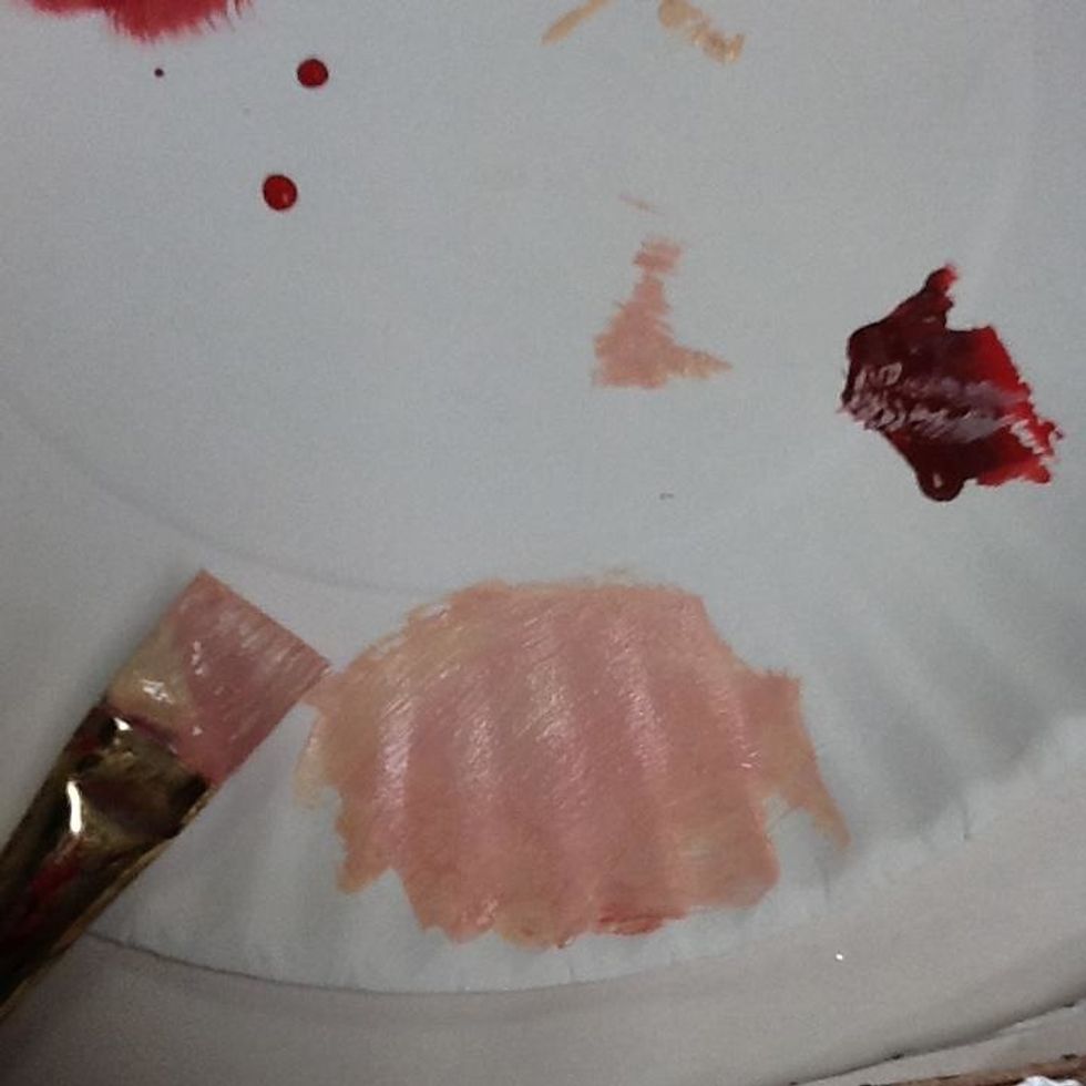 Mix a tiny amount of red with the peachy color to make a pinkish color.