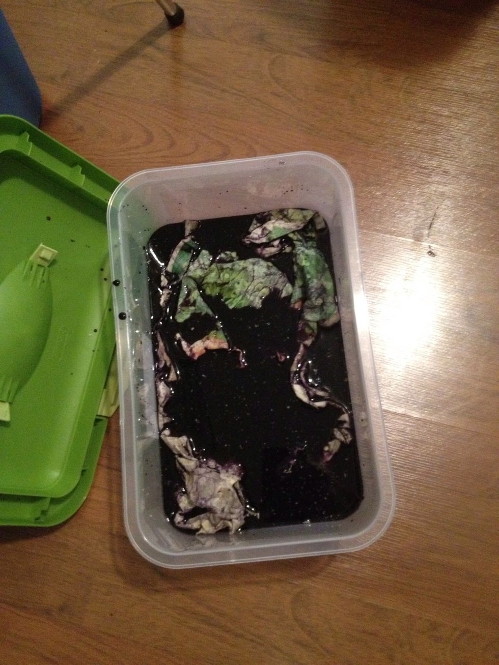 Mix black and violet dye into a plastic tub, submerge your waxed and crumbled art into the dye let it stand for about 15 min, check to see how dark the dye is in the cracks use your gloves to check