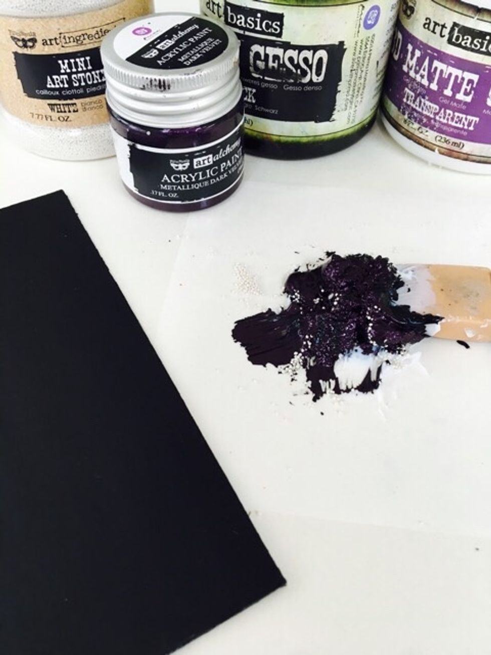 Mix Black Gesso with Art Alchemy 3D Matte Gel and Mini Art Stones. Lay this concoction heavily in the middle of the book fanning outwards.