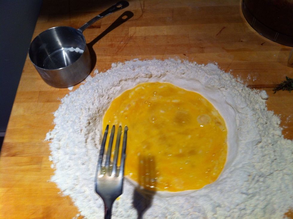 Mix eggs in well and incorporate into flour slowly using a fork to pull flour into egg mixture. Once you have a mass of dough together, knead for 10-15 min until you have a smooth ball of pasta dough