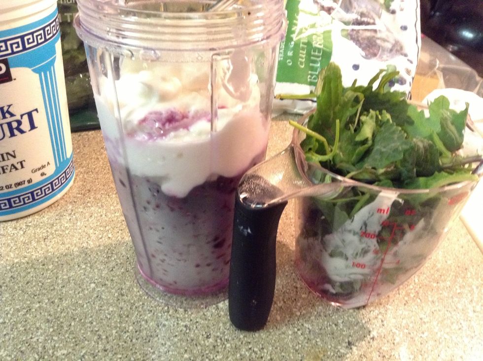 Mix in... Frozen blueberries. Greek yogurt. Kale. I'm using an upside down blender. Normally it's Water, Kale, Yogurt, Blueberries.