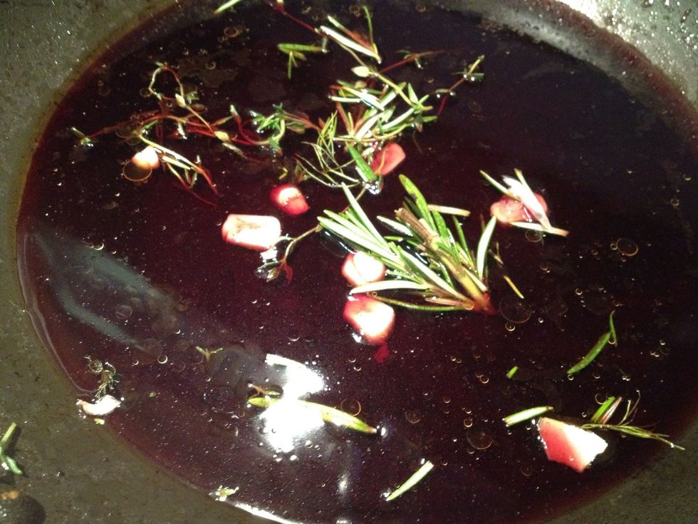 Mix in lamb stock, garlic, rosemary, and thyme into wine which will form the sauce for the lamb.