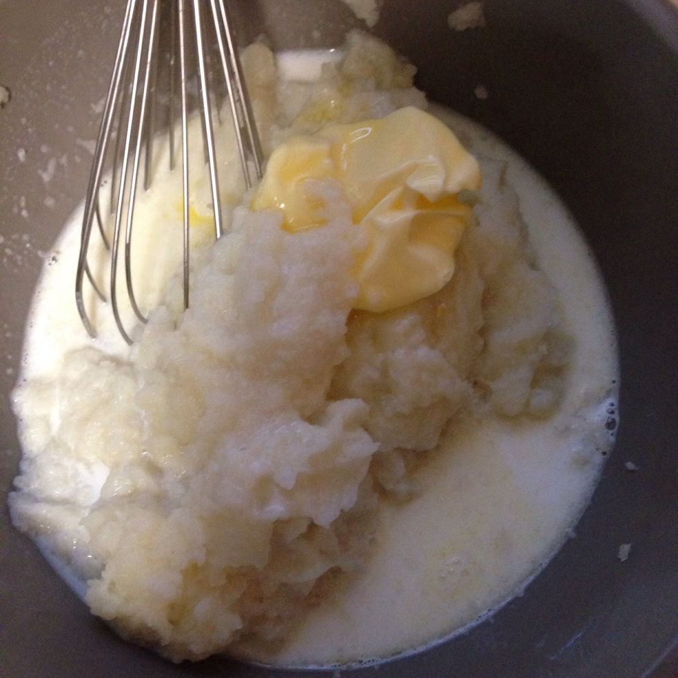 Mix it up with a heaping spoon of i can't believe its not butter , boiled milk, salt, pepper, shredded cheddar and green onions.