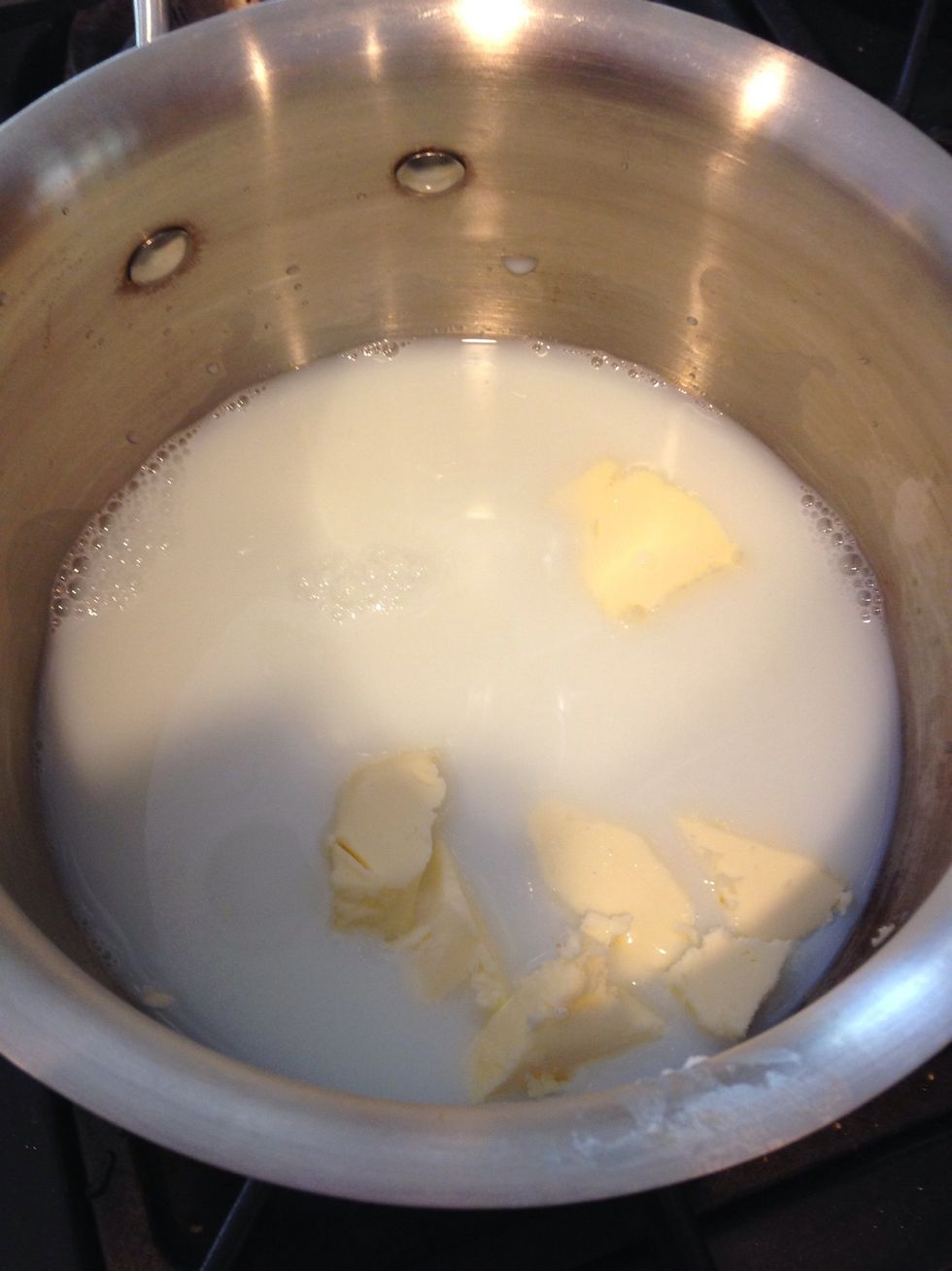 Mix milk, water, and butter in pan, heat until butter is melted.