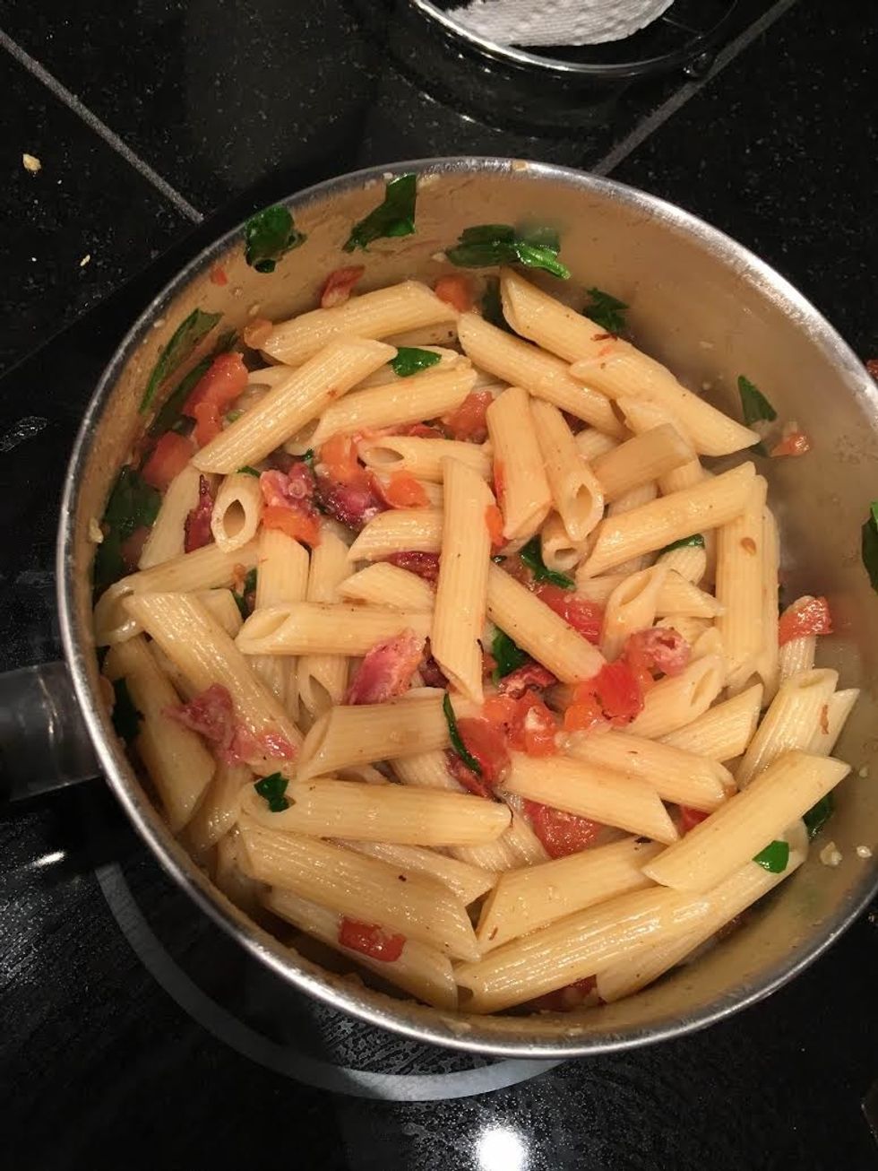 Mix pasta and spinach with tomatoes, garlic, bacon, and the remaining olive oil.