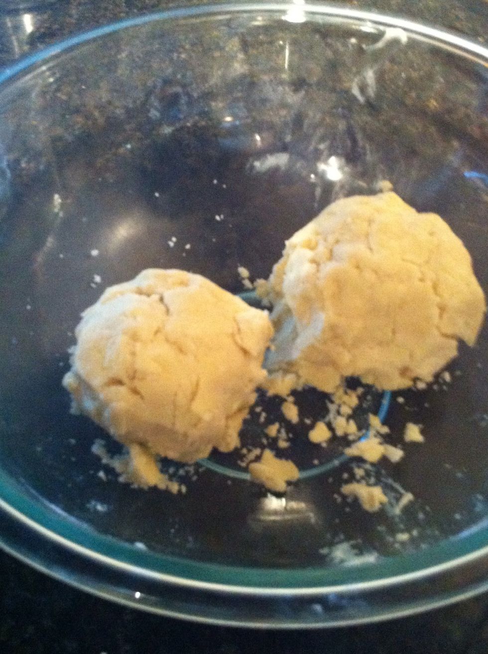 Mix the dough with your hands very lovingly. Gently fold the dough into the water well... Make sure not to mix too much or the crust will become tough! Form the dough into a ball and separate in half.