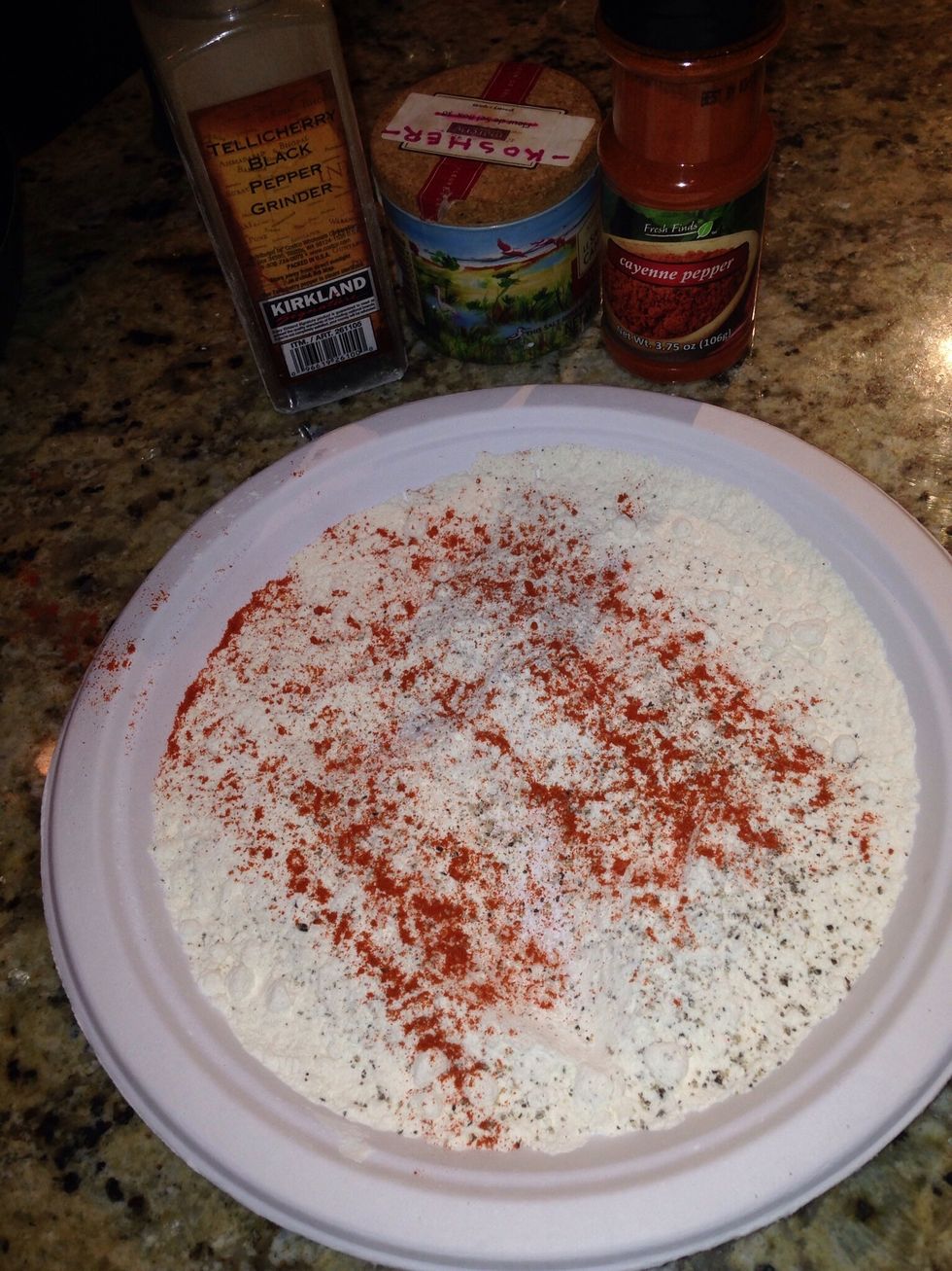 Mix the flour, salt, cayenne and pepper on a paper plate.