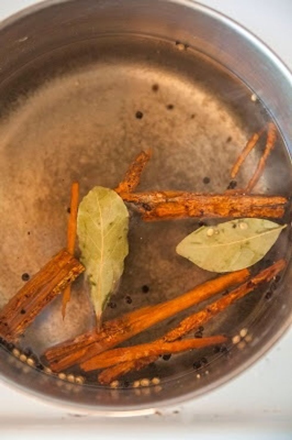 Mix the water and kosher salt together in a large pot. Toss in the bay leaves and peppercorns and cinnamon sticks. Bring everything to a strong boil.