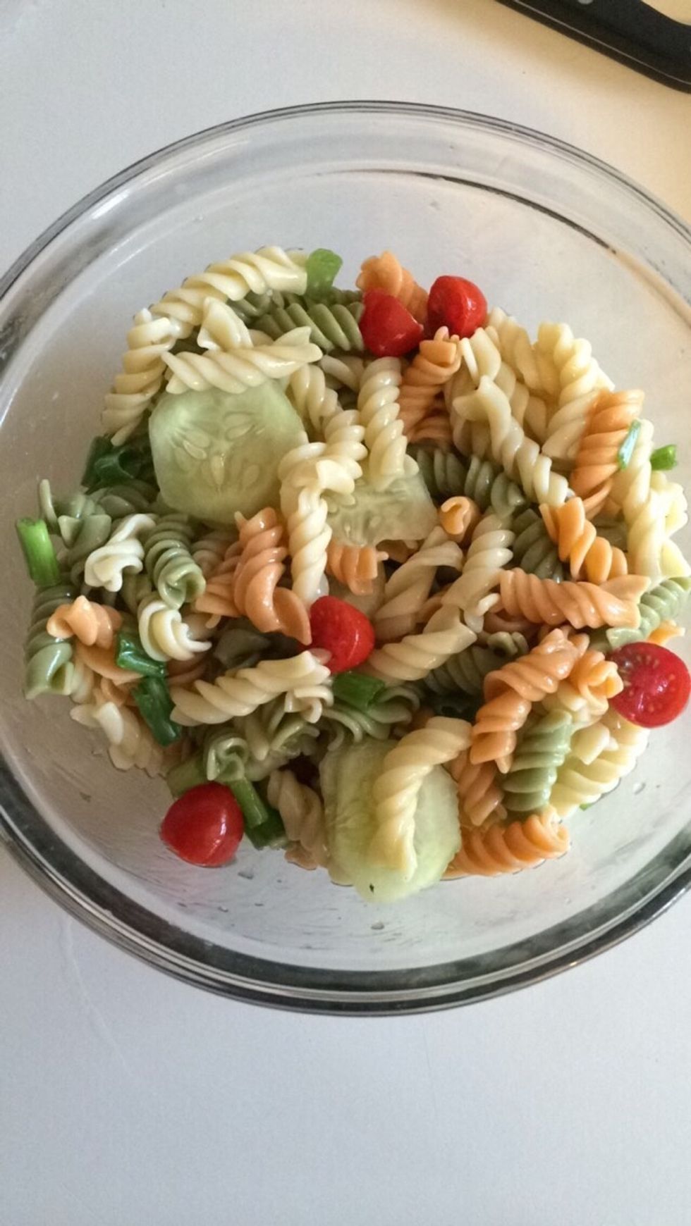 Mix tomatoes, green onions, and cucumbers into pasta