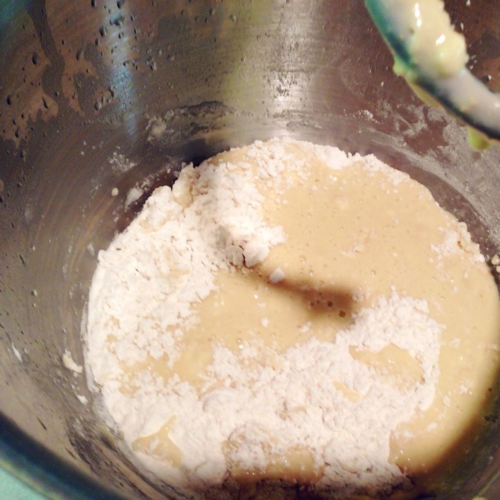Mix well, periodically scraping down the sides of the mixing bowl. Add remaining three to four cups of flour, one cup at a time. Let each cup of flour incorporate fully before adding more.