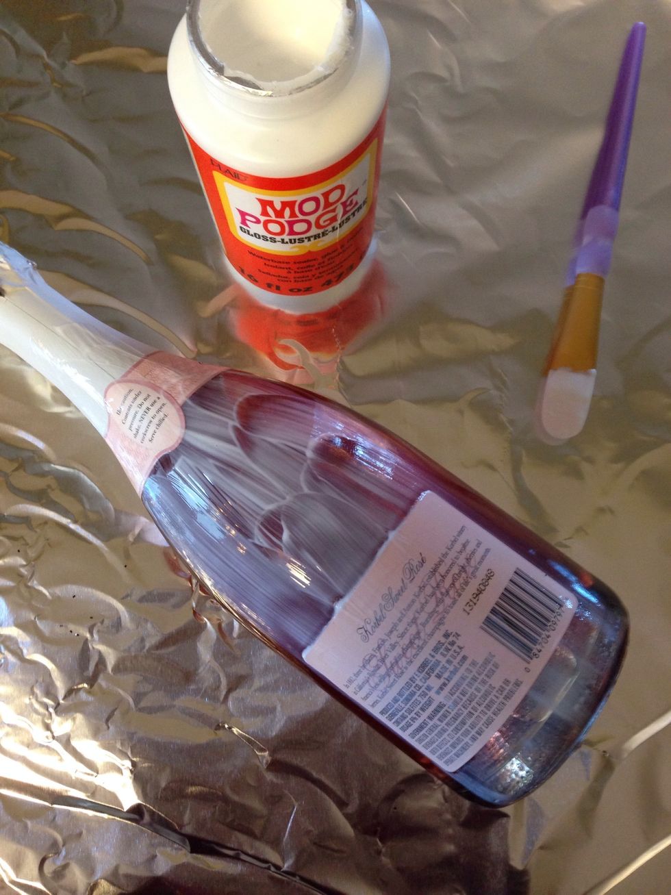 Mod Podge the bottle- work in sections so glue does not dry before adding glitter