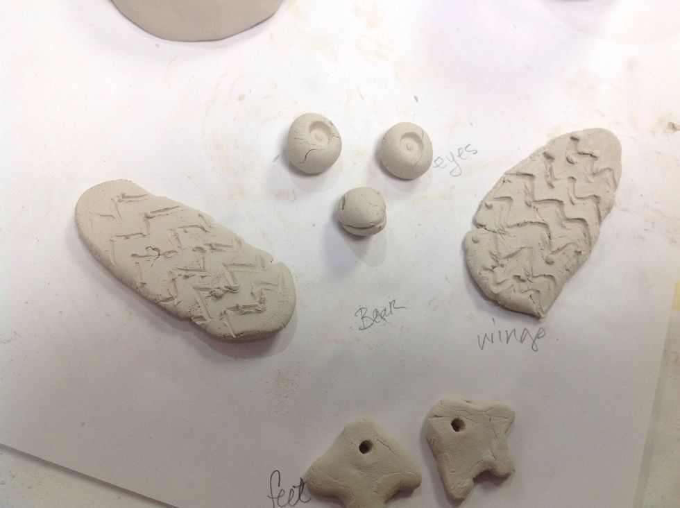 Mold the small pieces into eyes, wings, beak, and feet. Kinda like this. I used the top of a pen to add pupils to the eyes. Paper clips make cool feather patterns when pressed into clay.