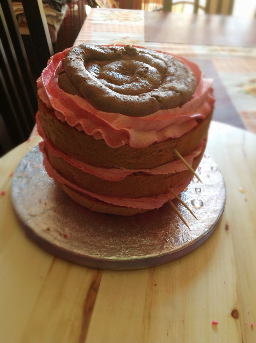 Montamos mojando con alm\u00edbar , hacemos un cerco con buttercream y rellenamos con ganache, y montamos las 4 capas juntando las marcas de los palillos y apretamos un poco. Si sobresale no pasa nada.